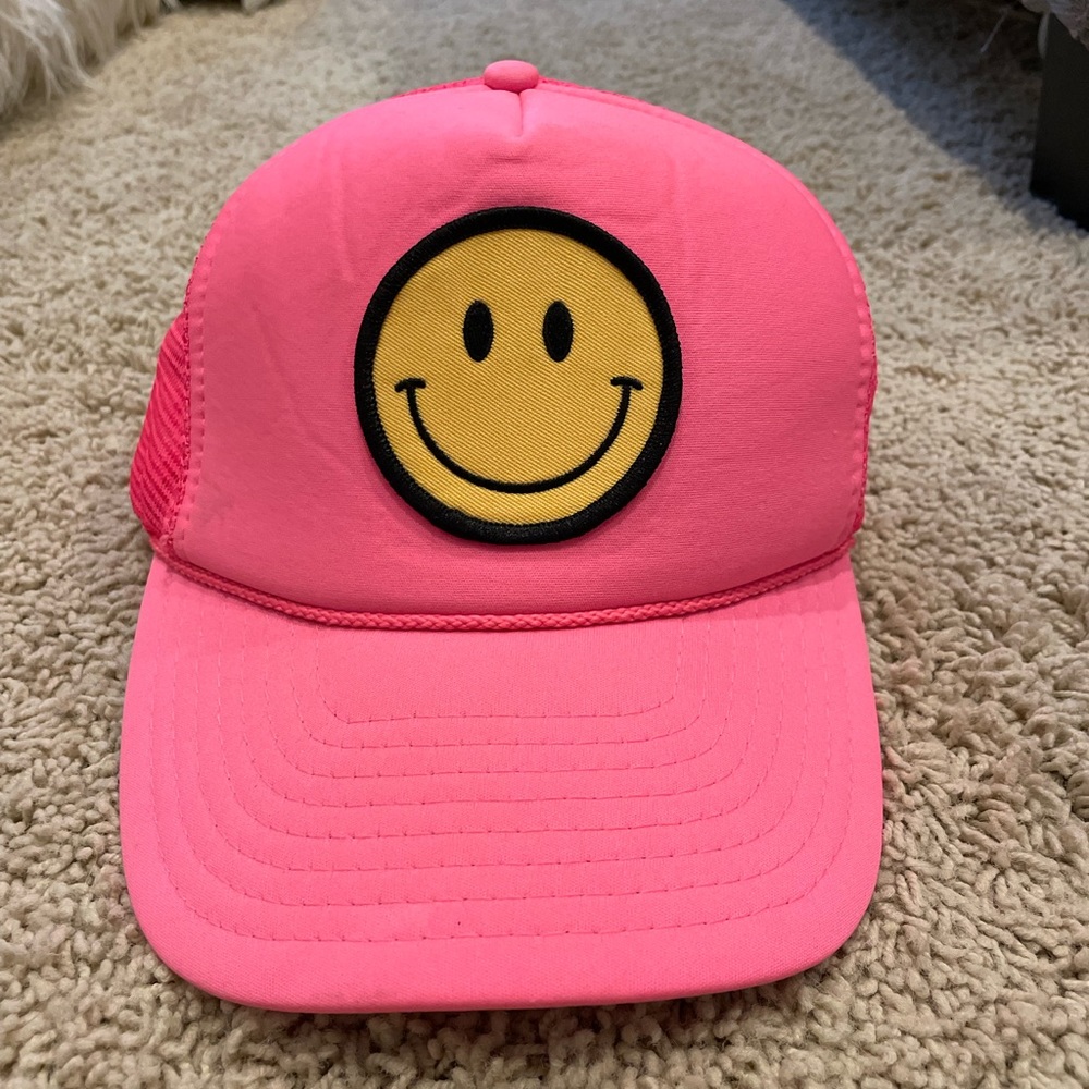 Neon pink smiley face trucker hat